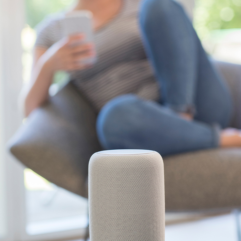 Woman listening to smart speaker on smart phone